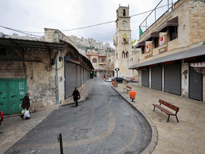 فلسطينيون يسيرون بجوار محلات مغلقة في مدينة نابلس القديمة. 23 فبراير 2023 - AFP