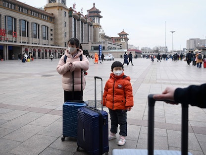 طفلان ينتظران قطارهما خارج مدخل محطة سكة حديد بكين في العاصمة الصينية. 7 يناير 2023 - AFP
