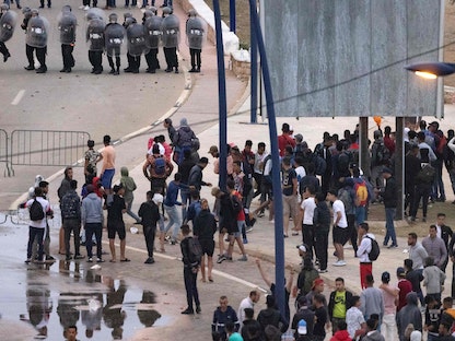 شرطة مكافحة الشغب المغربية تواجه مهاجرين في مدينة الفنيدق، يحاولون الوصول إلى جيب سبتة - 19 مايو 2021 - AFP