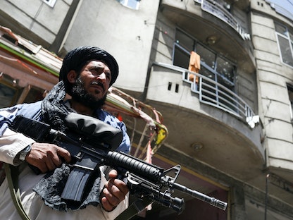 مقاتل من حركة "طالبان" يقف في حراسة الموقع الذي انفجرت فيه سيارة مفخخة وسط هجوم على معبد للسيخ في كابول بأفغانستان. 18 يونيو 2022  - REUTERS