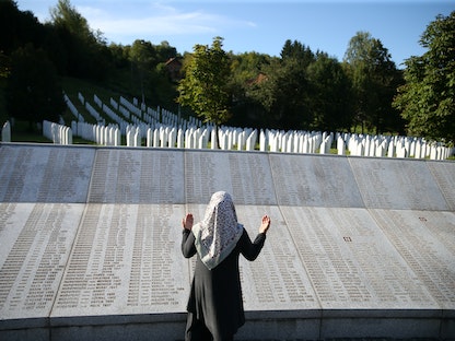 امرأة مسلمة تقف أمام النصب التذكاري للإبادة الجماعية في سريبرينيتسا، شرقي البوسنة - 26 أغسطس 2020. - REUTERS