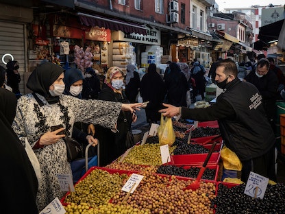 متسوّقة تدفع لبائع في سوق بإسطنبول - 2 فبراير 2021 - Bloomberg