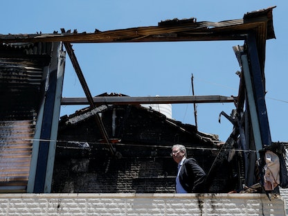 دبلوماسي أوروبي يتفقد مبنى فلسطينياً أحرقه مستوطنون إسرائيليون بالقرب من رام الله في الضفة الغربية. 23 يونيو 2023 - REUTERS