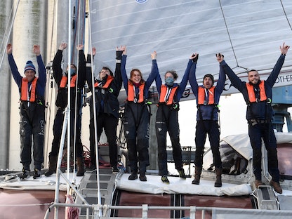 أفراد طاقم السفينة الشراعية "تارا" يلوحون عند مغادرة آخر معسكراتهم العلمية، قبالة ميناء لوريان غرب فرنسا. 12 ديسمبر 2020 - AFP