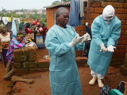 مسؤولان من منظمة الصحة العالمية يفحصان منزل أحد ضحايا فيروس ماربورج المشتبه به في بلدة أويج بشمال أنجولا. 19 أبريل 2005 - REUTERS