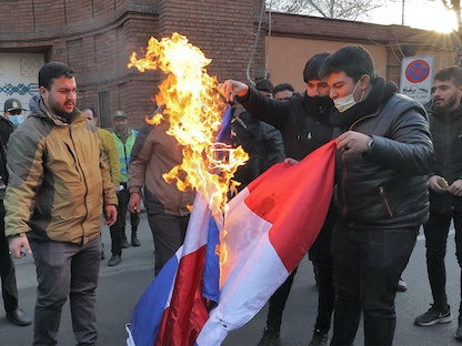 متظاهرون يحرقون العلم الفرنسي خلال احتجاج على رسوم كاريكاتورية لخامنئي نشرتها الأسبوعية الفرنسية الساخرة شارلي إيبدو . طهران - 8 يناير 2023. - AFP
