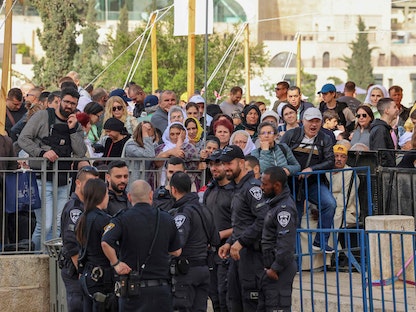 مسيحيون أوقفهم الاحتلال خارج كنيسة القيامة بالقدس القديمة لمنعهم من الدخول للاحتفال بالأعياد، 24 أبريل 2022 - AFP
