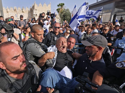 الشرطة الإسرائيلية تعتقل رجلاً فلسطينياً حاول اعتراض "مسيرة الأعلام" في القدس المحتلة – 29 مايو 2022 - AFP