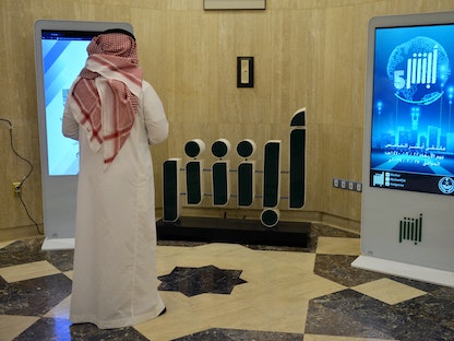 موظف بوزارة الداخلية السعودية يقف أمام شاشة تطبيق "أبشر" في مقر الوزارة بالرياض، ويسمح التطبيق بتجديد جوازات السفر والتأشيرات وتسهيل مجموعة متنوعة من الخدمات الإلكترونية - AFP