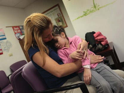 طفلة تعاني من آلام في المعدة داخل عيادة في مدينة أورورا بولاية كولورادو الأميركية- 28 يوليو 2009  - Getty Images via AFP