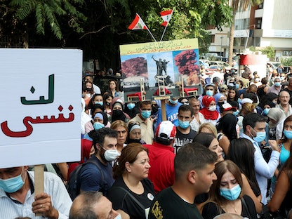 متظاهرون يرفعون لافتات تندد بتعليق التحقيق في انفجار مرفأ بيروت، لبنان، 29 سبتمبر 2021  - REUTERS