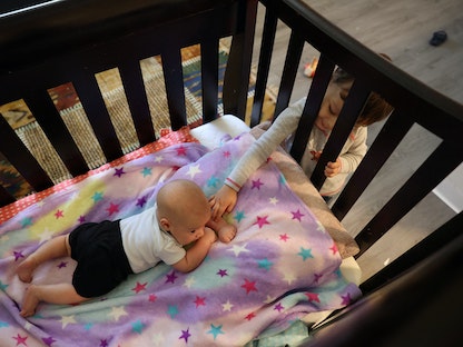 طفل يداعب أخيه الرضيع في منزلهما كاليفورنيا الولايات المتحدة - 29 يونيو 2022 - REUTERS