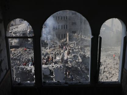 فلسطينيون بين أنقاض مباني دمرتها غارة إسرائيلية على مخيم البريج للاجئين في وسط قطاع غزة. 2 نوفمبر 2023 - AFP
