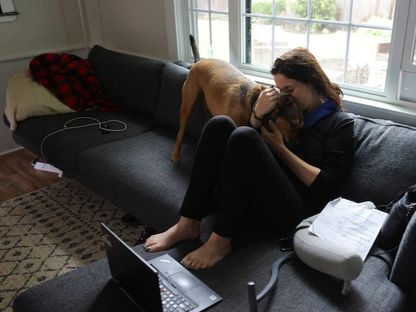 سيدة أميركية تعانق كلبها في منزلها في بيفرلي بولاية ماساتشوستس الأميركية. 6 سبتمبر 2022 - Reuters