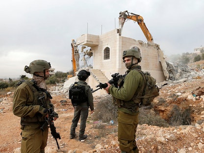 قوات إسرائيلية خلال هدم منزل فلسطيني في الخليل بالضفة الغربية المحتلة -  28 ديسمبر 2021 - REUTERS