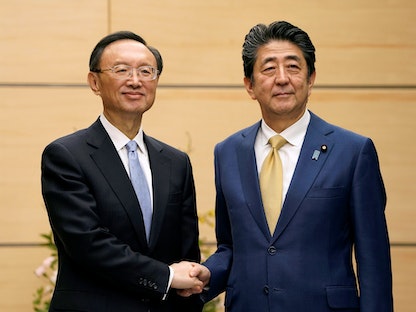 أبرز الدبلوماسيين الصينيين يانج جيتشي (يسار) خلال لقائه رئيس الوزراء الياباني السابق شينزو آبي في طوكيو - 28 فبراير 2020 - REUTERS