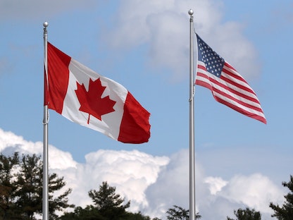 العلمان الأميركي والكندي عند المعبر الحدودي بين كندا والولايات المتحدة عند جسر ألف جزيرة، أونتاريو، كندا، 28 سبتمبر 2020. - REUTERS