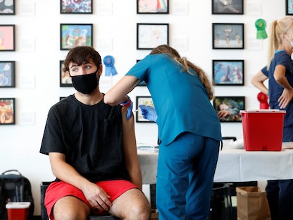 شاب أميركي يتلقى جرعة من لقاح فايزر المضاد لكورونا في أحد المراكز الطبية بولاية فلوريدا - REUTERS
