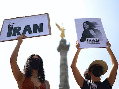 فتيات إيرانيات يتظاهرن احتجاجاً على وفاة مهسا أميني، مكسيكو سيتي، المكسيك - أكتوبر 2022 - REUTERS
