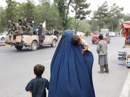 امرأة أفغانية مع أطفالها تمشي في شوارع العاصمة كابول. 15 أغسطس 2022.  - REUTERS