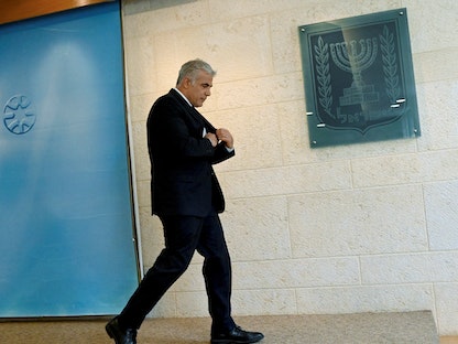 يائير لبيد في طريقه لتقديم إفادة صحافية بمقر وزارة الخارجية الإسرائيلية- 24 أبريل 2022 - REUTERS
