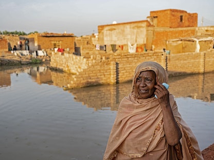 امرأة سودانية تنظر إلى شارع غمرته المياه في حي الكلاكلة الجنوبي بالعاصمة الخرطوم - 7 سبتمبر 2021. - AFP
