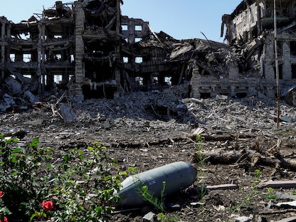 قنبلة غير منفجرة أمام مبنى مدمّر في مدينة ماريوبل جنوب شرقي أوكرانيا - 2 يونيو 2022 - AFP