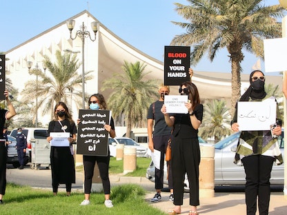 نساء كويتيات يرفعن لافتات تندد بالعنف ضد المرأة خلال تظاهرة احتجاجية بالكويت- 22 أبريل 2021 - AFP