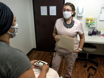 ممرضة تتحدث مع مريضة بعد اجراء فحص بالموجات فوق الصوتية في تكساس بالولايات المتحدة. 1 أكتوبر 2021 - REUTERS