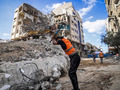 عمال وآليات تعمل على إزالة الأنقاض وآثار القصف الإسرائيلي على قطاع غزة - 5 يونيو 2021 - AFP