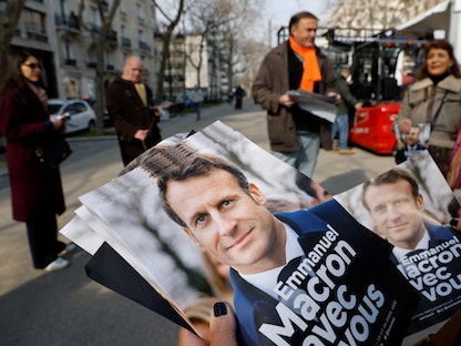 أعضاء في حزب "الجمهورية إلى الأمام" الفرنسي، يوزعون منشورات لحملة الرئيس الفرنسي ومرشح الحزب للرئاسيات- باريس - 5 مارس 2022 - AFP