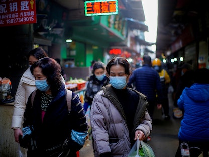 صينيون يرتدون أقنعة واقية في ووهان 28 فبراير 2021 - REUTERS