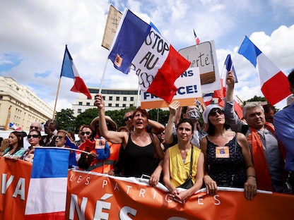 جانب من المظاهرات في العاصمة الفرنسية باريس احتجاجاً على القيود المفروضة لاحتواء تفشي فيروس كورونا والشهادة الصحية، 31 يوليو 2021 - REUTERS