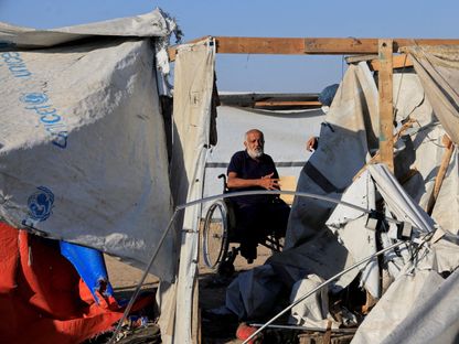 فلسطينيون يتفقدون موقع غارة إسرائيلية استهدفت خيمة تؤوي نازحين في خان يونس بجنوب قطاع غزة. 5 أغسطس 2025 - Reuters