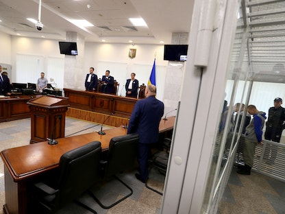 جندي روسي مشتبه بارتكابه انتهاكات لقوانين وأعراف الحرب داخل قفص خلال جلسة محكمة بكييف - 23 مايو 2022. - REUTERS