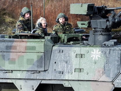 وزيرة الدفاع الألمانية كريستين لامبريشت تجلس فوق دبابة خلال زيارتها لقاعدة مونستر - ألمانيا- 7 فبراير 2022 - REUTERS