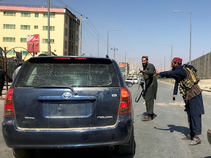 مقاتلان من حركة طالبان خلال تفتيش إحدى المركبات في العاصمة الأفغانية كابول. 16 أغسطس 2021 - REUTERS