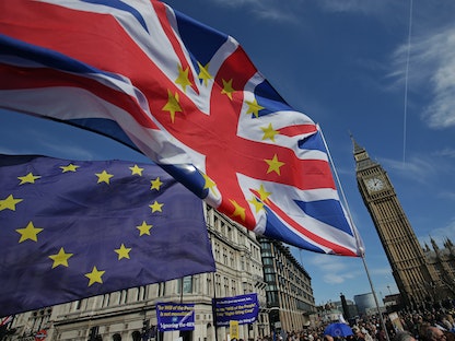 متظاهرون يلوحون بعلمي الاتحاد الأوروبي والمملكة المتحدة خلال مسيرة في لندن 25 مارس 2017 - AFP