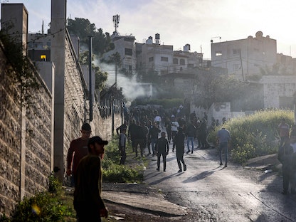 فلسطينيون يتجمعون على طول طريق خلال غارة إسرائيلية على مخيم جنين للاجئين في الضفة الغربية المحتلة. 7 مارس 2023 - AFP