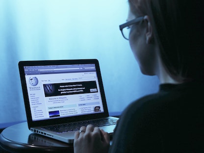 امرأة تتصفح موسوعة ويكيبيديا عبر حاسوب محمول في العاصمة الأميركية واشنطن - 17 يناير 2012 - REUTERS