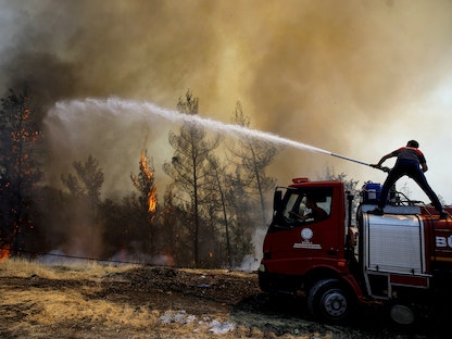 رجل إطفاء يحاول إخماد حريق هائل بالقرب من مرماريس في تركيا، 1 أغسطس 2021 - REUTERS