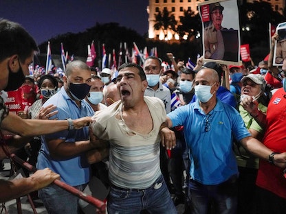 يعتقلون متظاهراً خلال مسيرة في هافانا، 17 يوليو 2021 - REUTERS