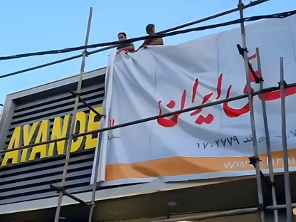 عمال يوارون لافتة 'بنك آينده' الخاص بلافتة جديدة بعد قرار البنك المركزي الإيراني بحلّه ودمجه في بنك 'ملي' الحكومي. - متداولة عبر وسائل التواصل الاجتماعي