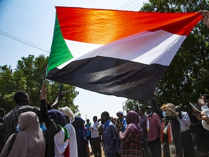 متظاهرون يرفعون العلم السوداني خلال احتجاجات بالعاصمة الخرطوم - 30 سبتمبر 2021 - Getty Images