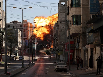 ألسنة النار تتصاعد بعد غارة إسرائيلية على "بنك الإنتاج" في قطاع غزة - AFP