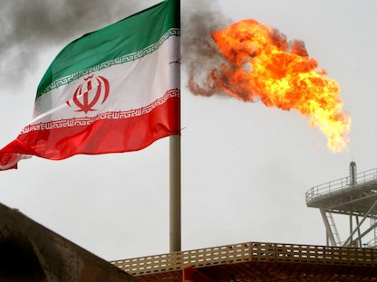  شعلة غاز على منصة لانتاج النفط بجانب العلم الايراني - 25 يوليو 2005 - REUTERS