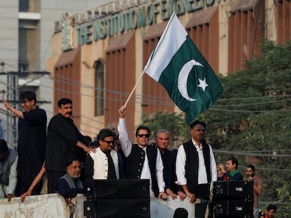 رئيس الوزراء الباكستاني السابق عمران خان يحمل علم بلاده خلال مسيرة في مدينة لاهور الباكستانية، 28 أكتوبر 2022 - REUTERS