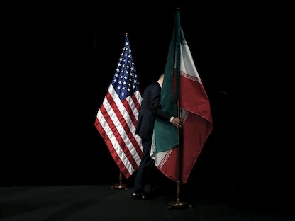 موظف في "مركز فيينا الدولي" يرفع العلم الإيراني بعد صورة جماعية خلال المحادثات النووية الإيرانية- النمسا - 14 يوليو 2015 - REUTERS