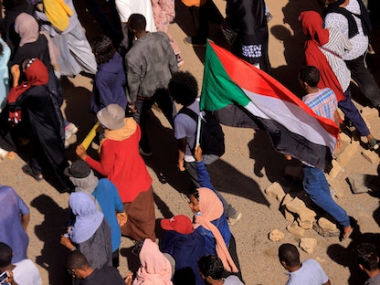 متظاهر يحمل علم السودان في الخرطوم، 4 يناير 2021. - REUTERS