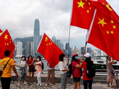 نشطاء يحملون أعلاماً صينية في ذكرى عودة هونغ كونغ إلى الحكم الصيني - 1 يوليو 2021 - REUTERS